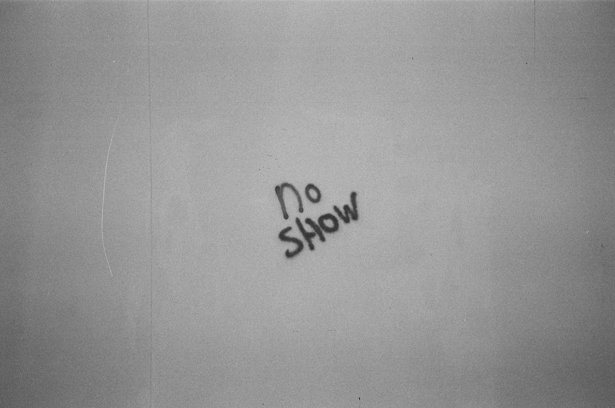 Graffiti text 'No Show' on a Breda wall. Artistic black and white.